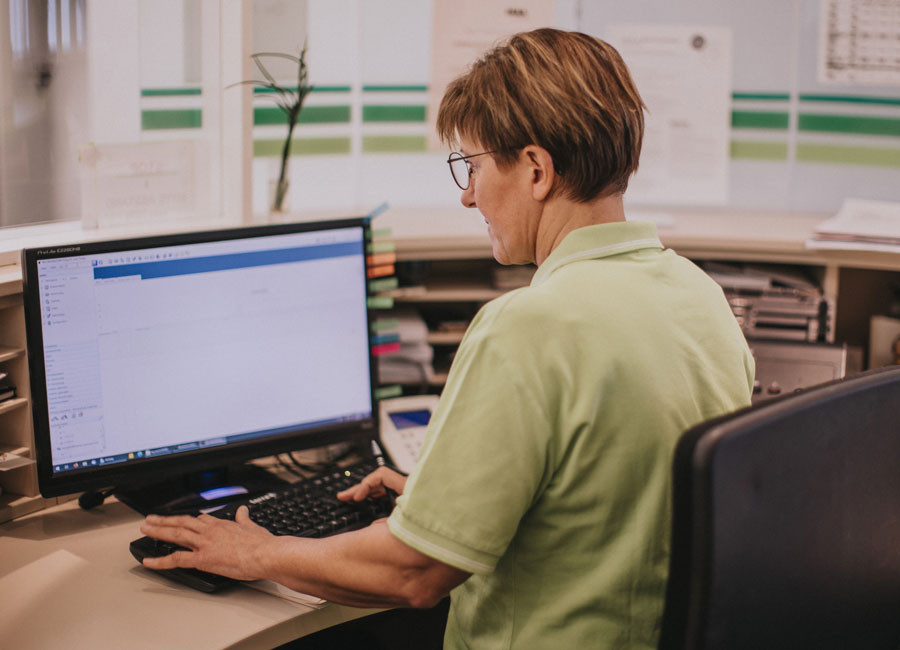 Mitarbeiterin sitz an der Rezeption Mitarbeiterin sitz an der Rezeption